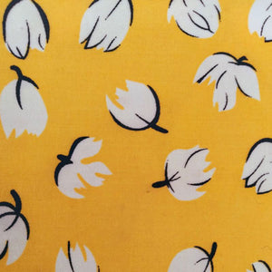 Bee wrap avec pour motif des grosses fleurs blanches et noires sur fond de couleur jaune